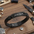 Uniqal BLACK LEGACY Armband aus schwarzem Echtleder auf Holztisch – Gravur 'Ich liebe Dich' als Symbol für Liebe, Nähe und ewige Verbundenheit